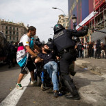 Mosso d'Esquadra cargando porra en mano contra un hombre en silla de ruedas