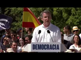 Feijóo dice que la manifestación de hoy es una manifestación sin siglas ni partidos mientras ondea tras el una bandera con las siglas del PP